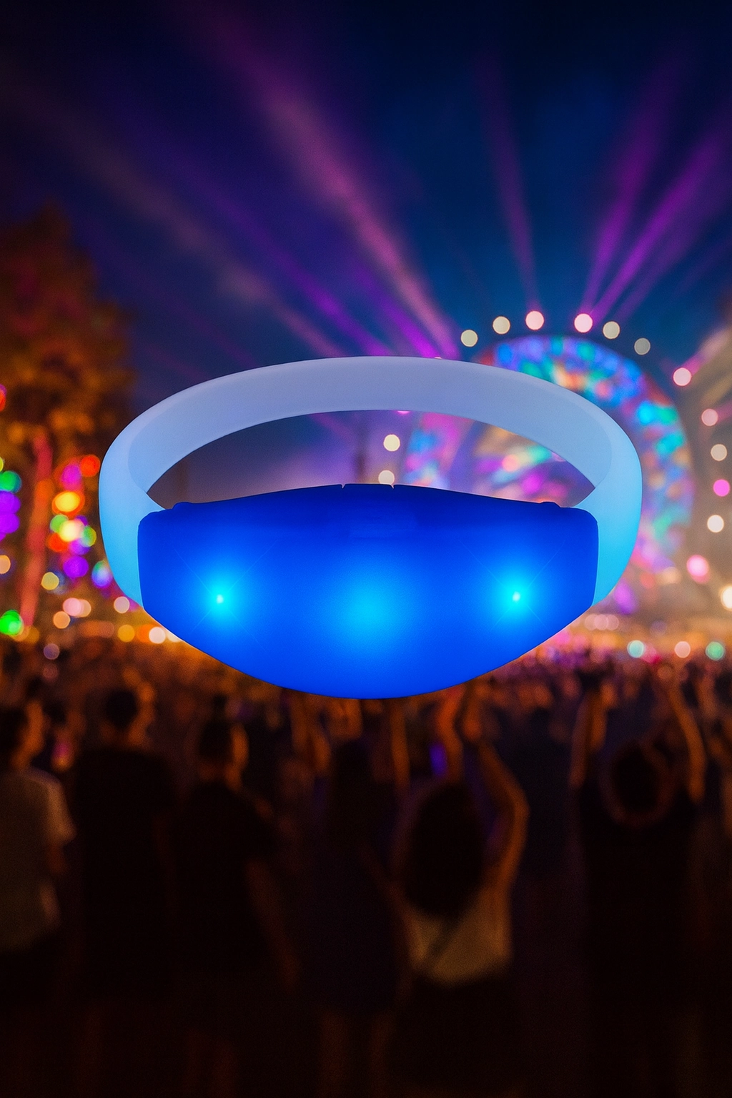Glowing blue LED wristband floating in front of a vibrant music festival crowd with colorful stage lights and lasers in the background at night.