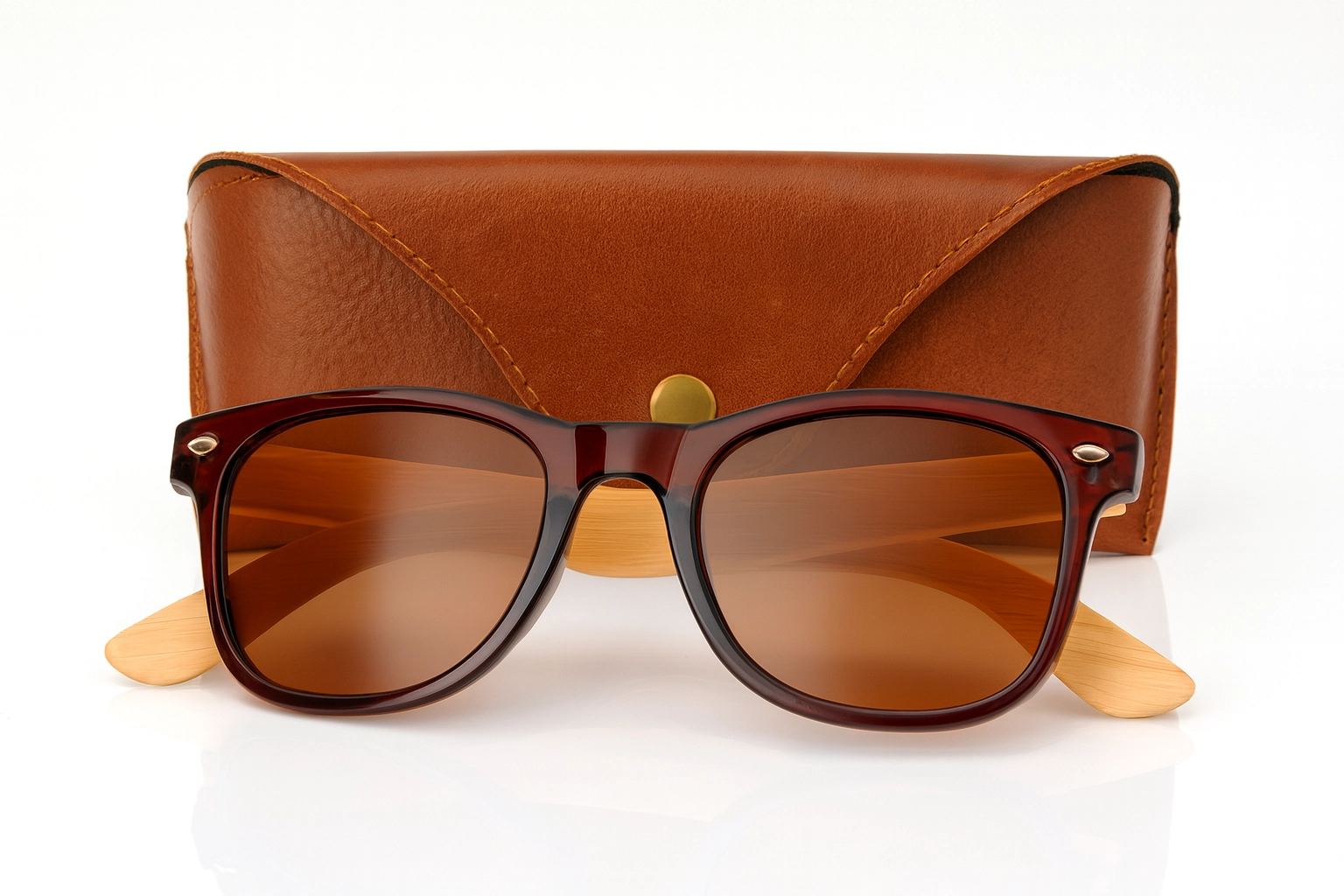 Branded sunglasses with bamboo arms and brown-tinted lenses displayed in front of a stylish brown leather pouch on a neutral background.