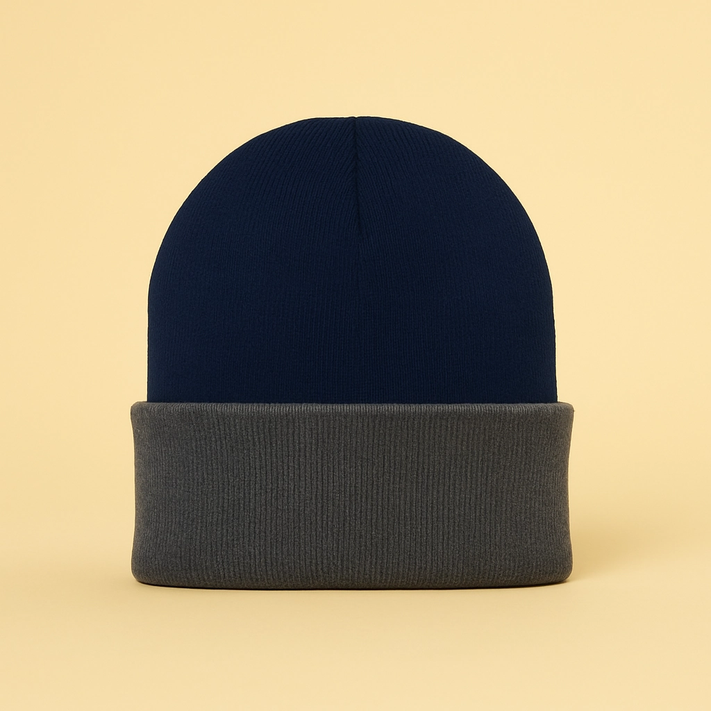 Two-tone knit beanie with a navy crown and gray cuff displayed against a soft yellow studio background.