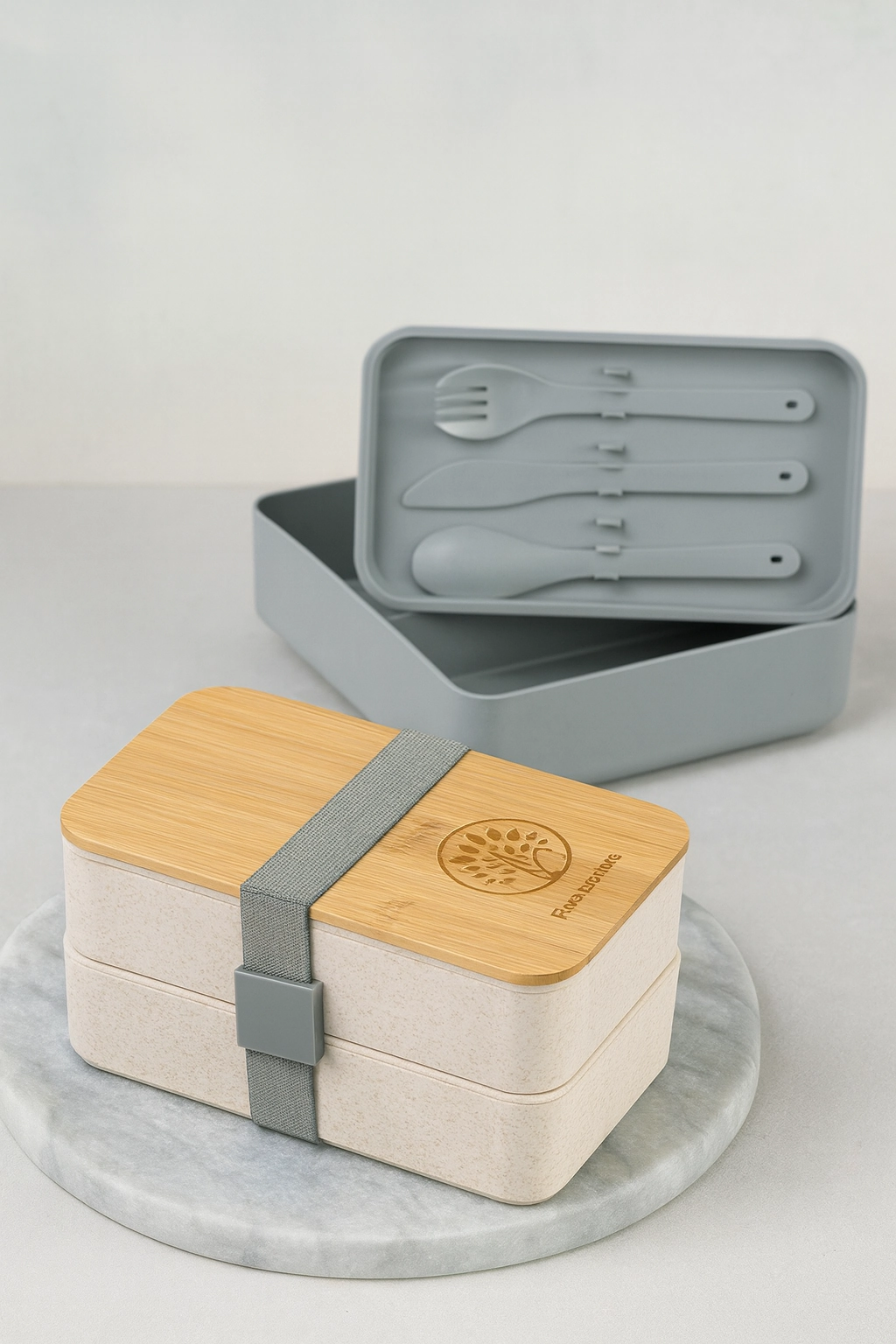 Eco-friendly bento lunchbox with bamboo lid and utensils, displayed on a clean office breakroom table to promote staff culture and functional swag